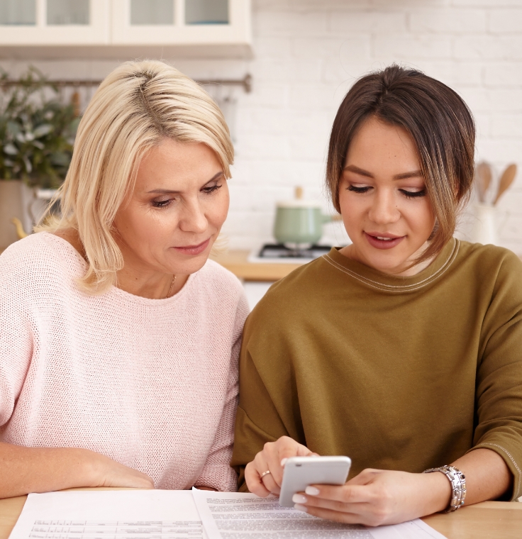two women looking at calculator